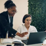 Two businesswomen working together at the desk