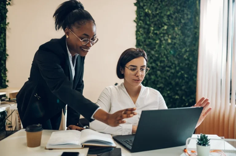 Two businesswomen working together at the desk