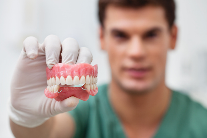 Male practitioner holding dental mold