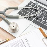 Stethoscope and prescription on laptop